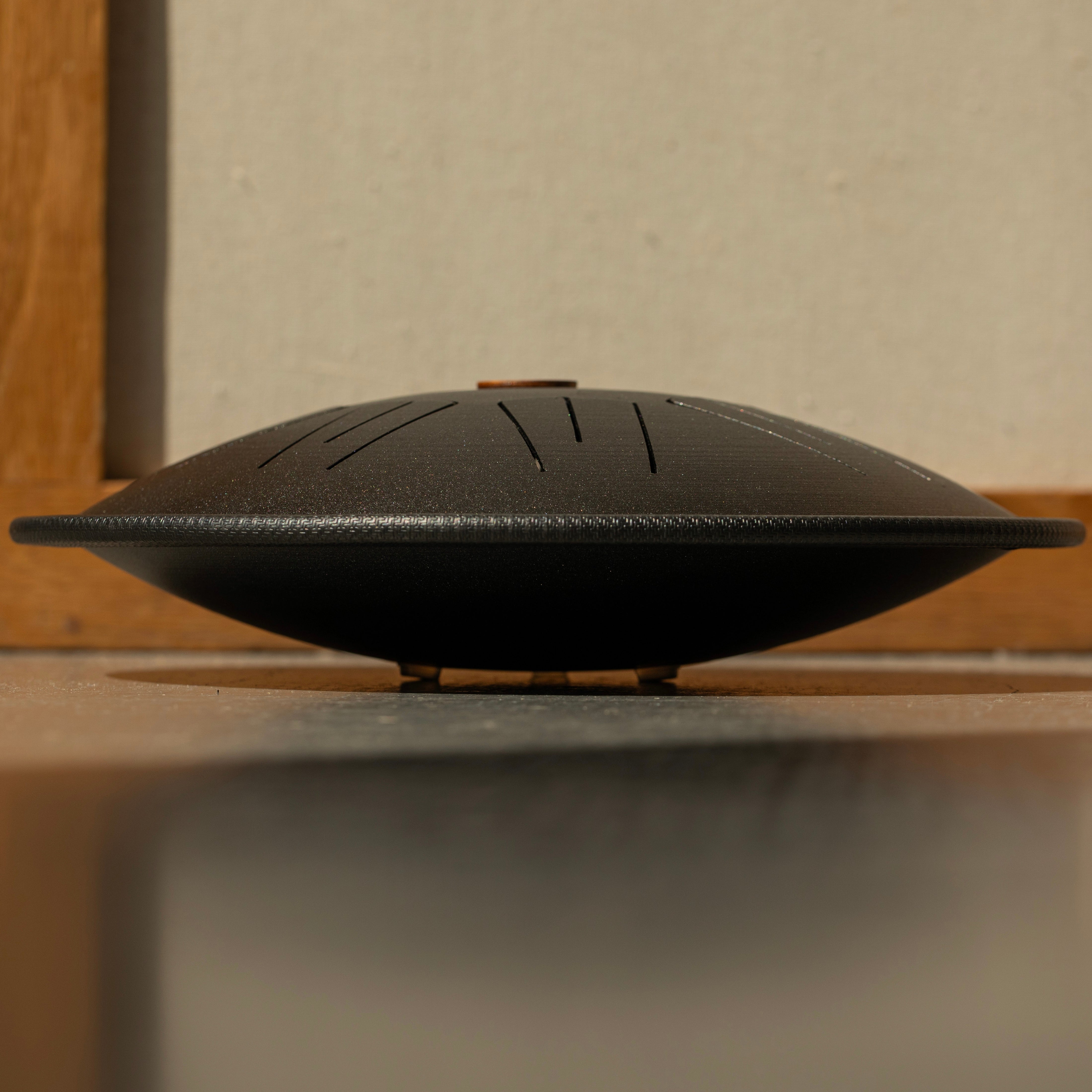 Side view of Burning27 Spark steel tongue drum showing curved shape