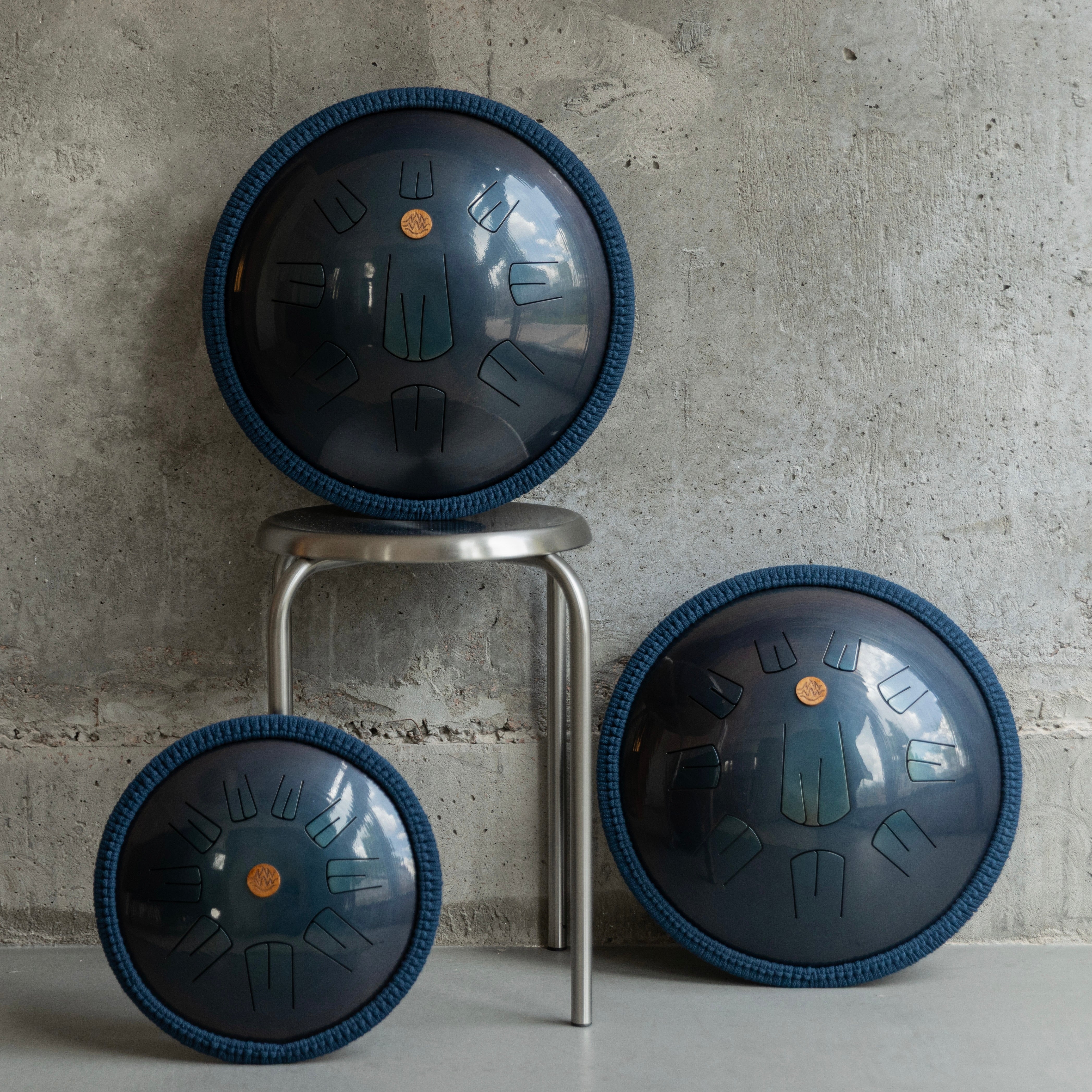 Burning27 handmade steel tongue drums in different sizes with wall-background