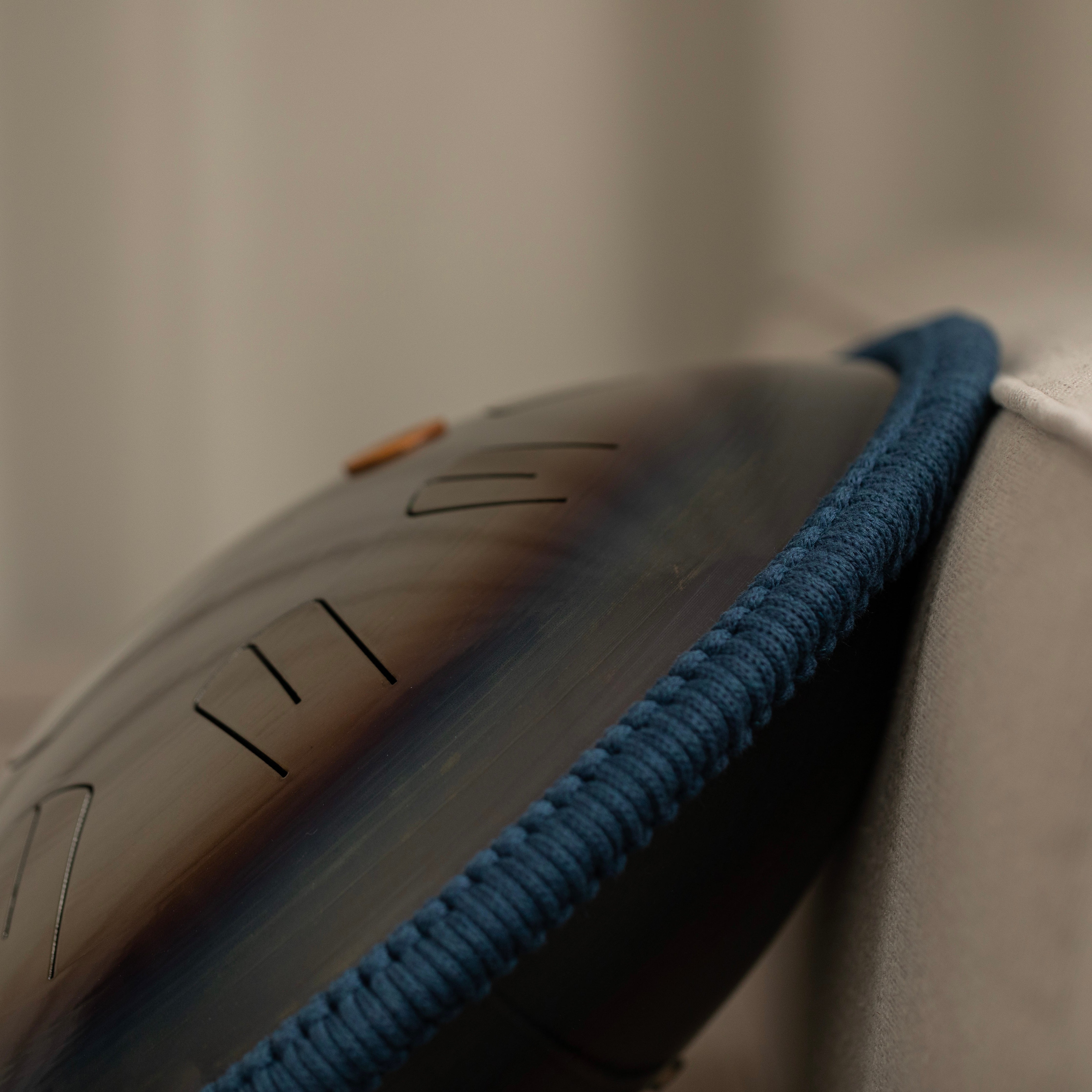 Detailed side view of Burning27 Ember steel tongue drum model with rope braid