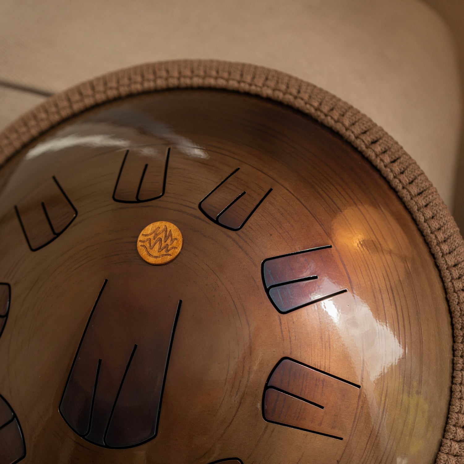 Handcrafted steel tongue drum in bronze color, golden amber design by Burning27 workshop