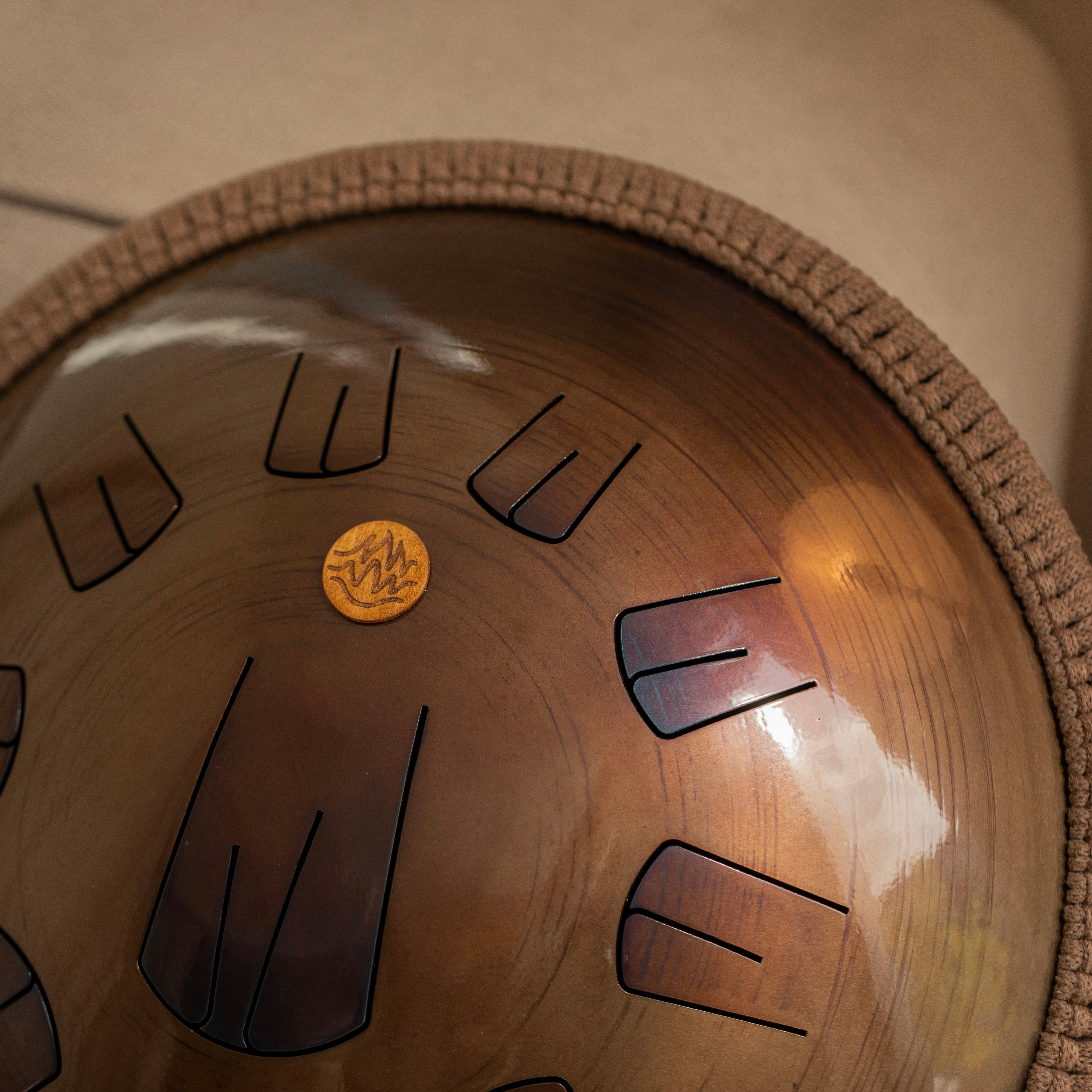 Handcrafted steel tongue drum in bronze color, golden amber design by Burning27 workshop