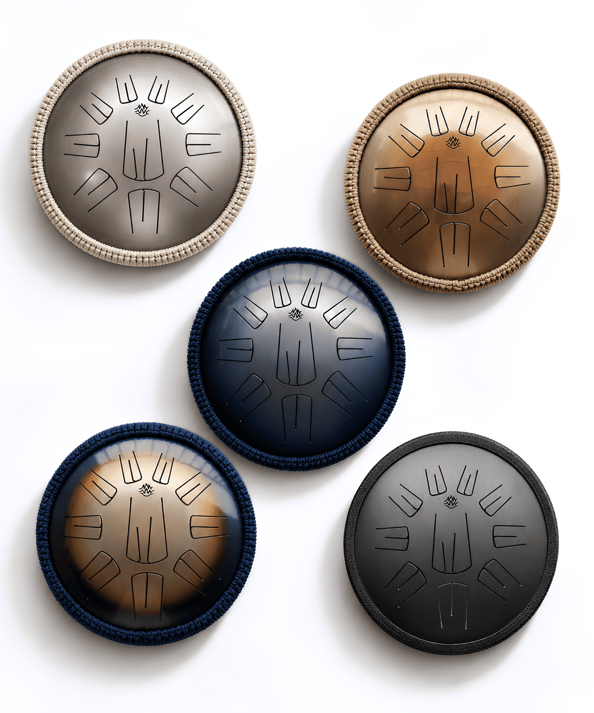 Five handmade steel tongue drums in different finishes and colors, arranged on a light beige background. The set includes silver, bronze, dark blue, rainbow, and black drums. Burning27 Workshop